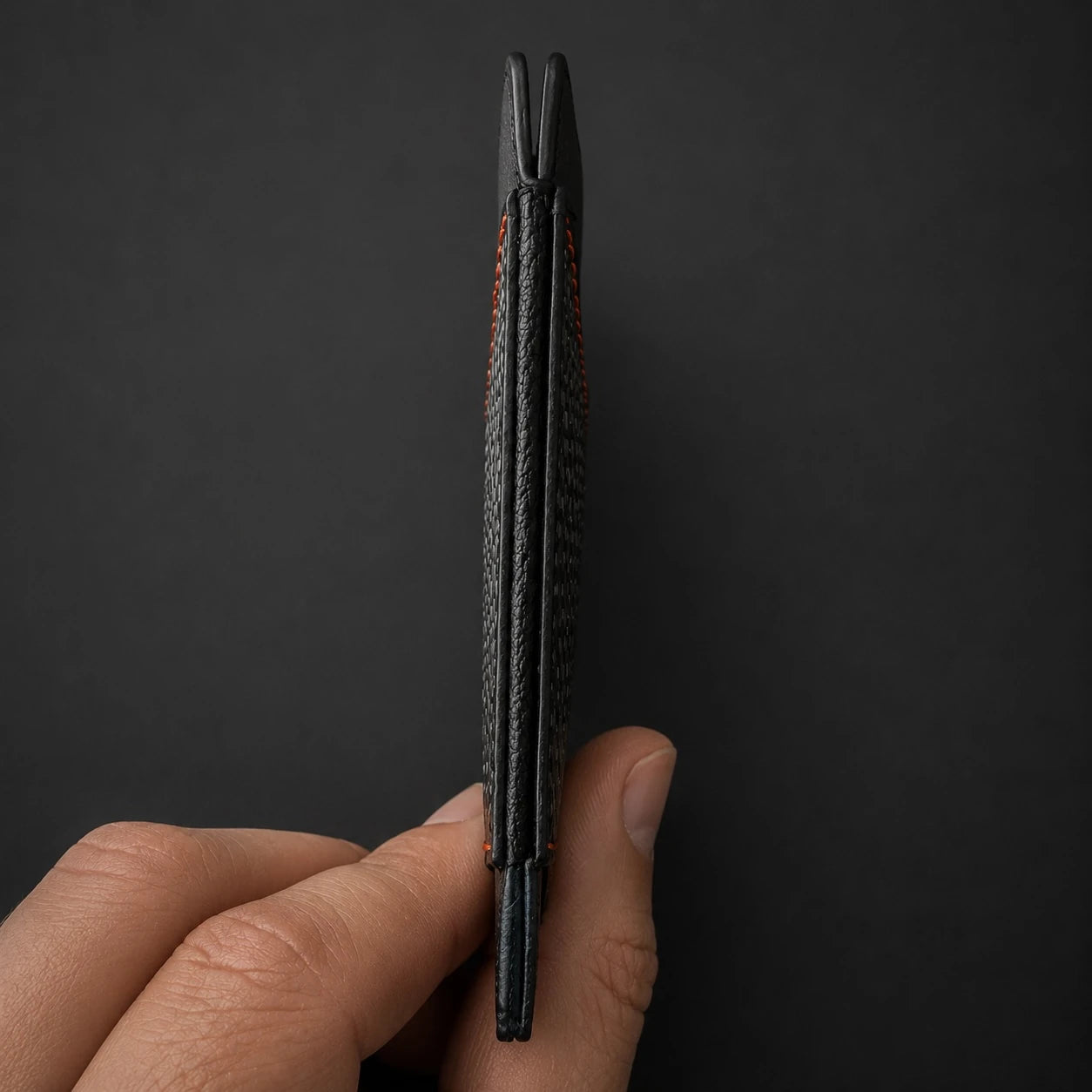 COLDFIRE Scout One held edge-on between fingers, showing its 5 mm slim profile